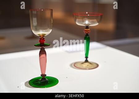 Two colorful art glass goblets displayed on a white surface, likely in a museum or gallery setting. The foreground goblet features a clear bowl with Stock Photo