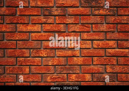 Close-up of a red brick wall showing rough texture, mortar joints and warm reddish-brown tones; ideal as background, architectural detail or construct Stock Photo