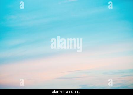 Pastel sky at sunrise with soft pink clouds and calm blue gradient background for tranquil moods Stock Photo