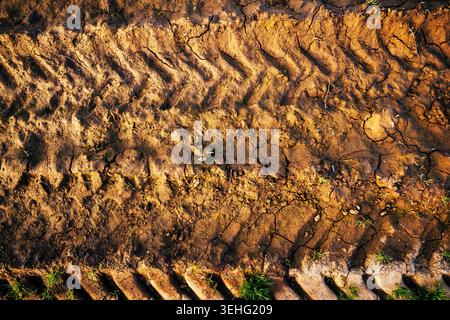 Tractor tire tracks in dry cracked soil on rural farmland, top view Stock Photo