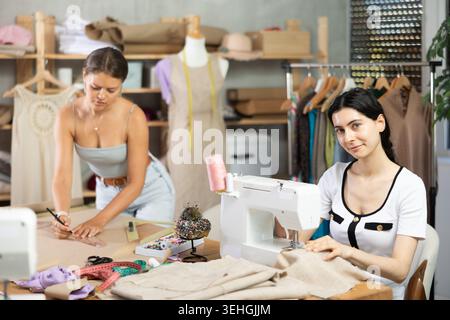 Two female tailors working on custom garment in studio Stock Photo