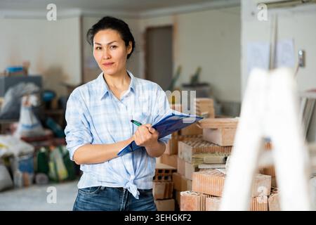 Woman making notes at renovating house Stock Photo