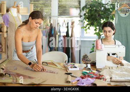 Female fashion designer drafting patterns in sewing workshop Stock Photo
