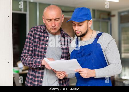 Builder and owner of apartment discussing renovation works Stock Photo