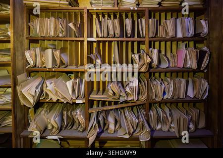 Abandoned archive room. Old documents on shelves. Stock Photo