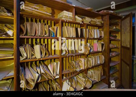Abandoned archive room. Old documents on shelves. Stock Photo