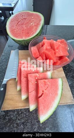 Fresh Cut Watermelon Slices and Cubes on Kitchen Countertop Stock Photo