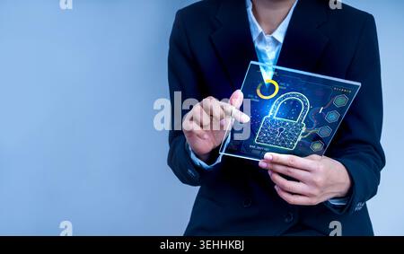 Business professional holding digital tablet with cybersecurity lock icon interface. Data protection, network security, and information security techn Stock Photo