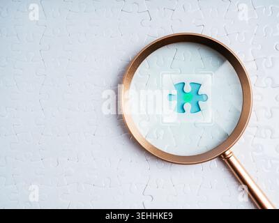Magnifying glass focusing on missing puzzle piece with checkmark icon. Problem solving, verified solution, data validation, quality control, decision Stock Photo