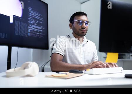 Indian Software Developer Working On AI Code In Modern Tech Office Stock Photo