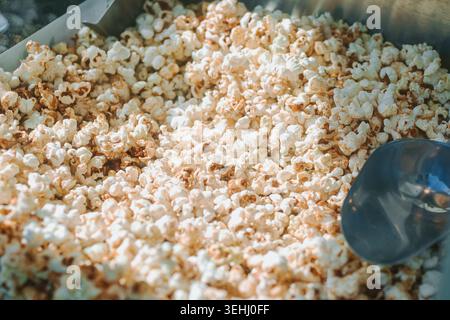 Valmiera, Latvia - May 23, 2026: Warm freshly popped popcorn filling a cinema snack machine in soft natural light. Appetizing close-up texture ideal f Stock Photo
