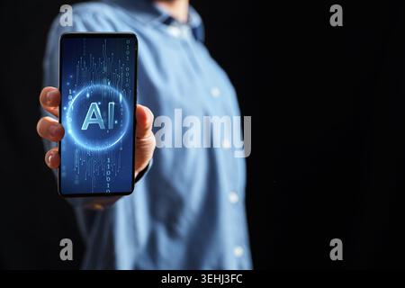 Hand holding a modern smartphone screen displaying AI text, representing artificial intelligence technology Stock Photo