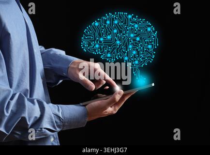 Person using a touchscreen tablet, connecting with a glowing circuit board brain representing artificial intelligence, machine learning and innovation Stock Photo