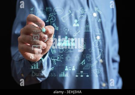 Hand drawing a holographic business strategy with various icons, outlining planning, innovation, and futuristic technology Stock Photo