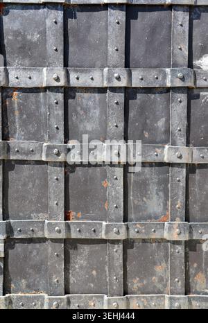 Metallic retro door with vintage rivets, metal hardware. Medieval metal shutter adorned with variety of metal fixtures. Can be used for steampunk, mec Stock Photo