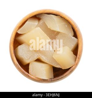 Mustard pickled gherkins in a wooden bowl. Sweet and sour pickled gherkins, cucumber chunks, pasteurized and preserved in a brine. Stock Photo