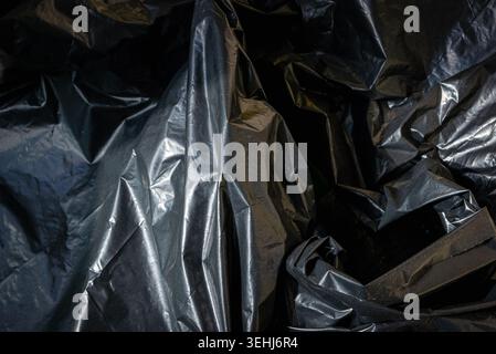 Plastic crumpled black texture garbage bag background. Stock Photo