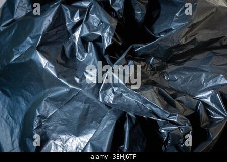 Plastic crumpled black texture garbage bag background. Stock Photo