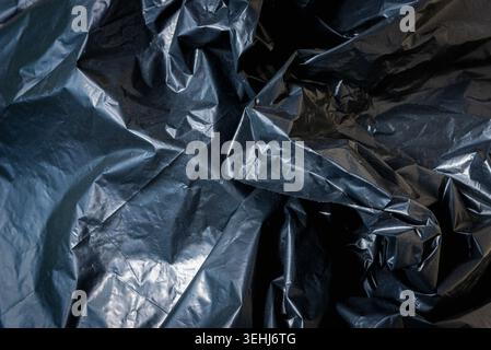 Plastic crumpled black texture garbage bag background. Stock Photo