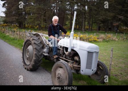 Farmer using a vintage tractor on his farm near beauly Inverness shire Scotland Stock Photo