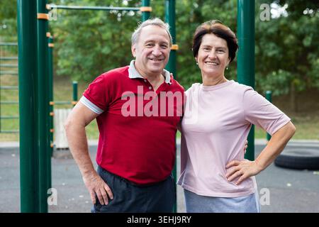 Elderly man and woman posing in open-air sports bars complex Stock Photo