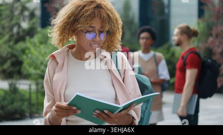 African American student girl female woman reading book studying showing thumb up like smile recommend study learning course read literature smiling Stock Photo