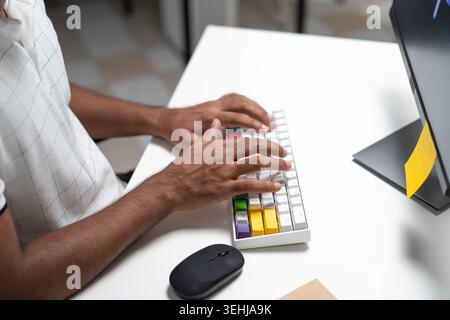 Indian Professional Typing On Keyboard At Modern Office Desk Stock Photo