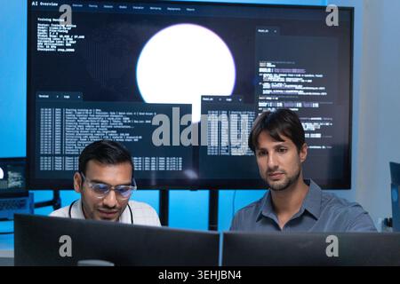 Software Developers Working With AI Code On Computers In Tech Office Stock Photo