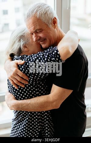 Senior man and woman sharing hug Stock Photo