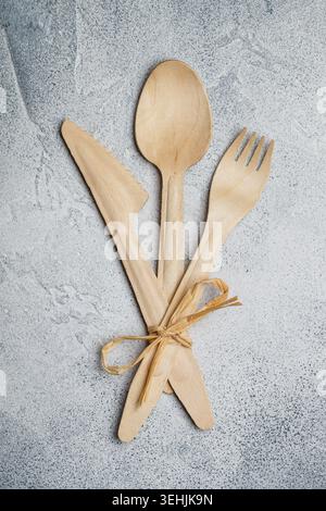 Eco friendly wooden cutlery-spoon, fork and knife on a grey background. Plastic free concept. Selective focus, copy space Stock Photo