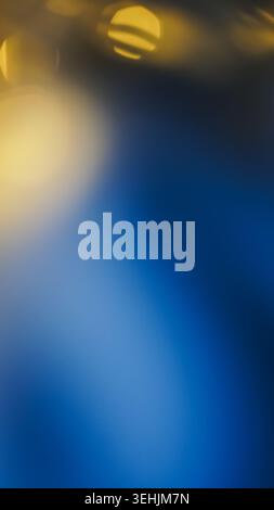 Soft golden bokeh lights glow against a deep blue smooth gradient background. Stock Photo