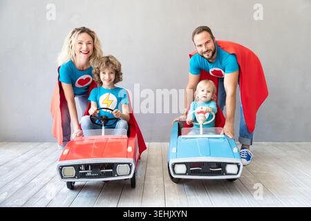 Family of superheroes playing at home. Father, mother, daughter and son having fun together. Parents with children pretend to be a super heroes Stock Photo