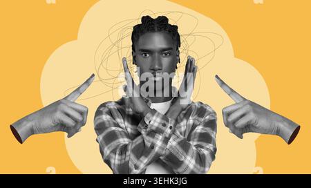 A Young Man Stands With His Arms Crossed, Looking Serious Stock Photo