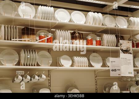 White kitchen plates and dining accessories displayed on shelves inside IKEA store in Belgrade. Belgrade, Serbia - May 12, 2026. Stock Photo