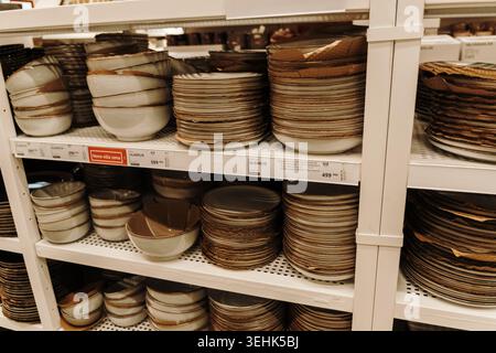 Ceramic bowls and plates displayed on shelves inside IKEA store with earthy minimalist design. Belgrade, Serbia - May 12, 2026. Stock Photo