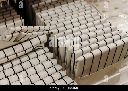 Neatly folded striped kitchen towels arranged on retail shelves in a modern home goods department. Clean textile concept for household and hospitality Stock Photo