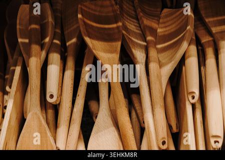 Assorted wooden spatulas and cooking utensils displayed in a home goods store. Natural kitchen accessory concept with rustic lifestyle aesthetics. Stock Photo