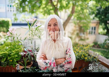 Portrait of beautiful senior woman standing on balcony. Stock Photo