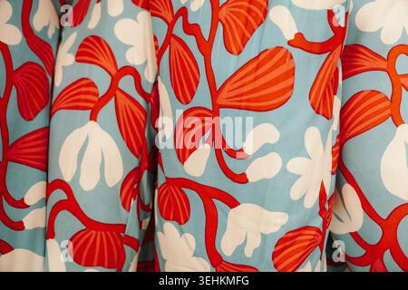 Vibrant floral fabric with red and white botanical elements on blue background. Decorative textile concept for modern interior and fashion themes. Stock Photo