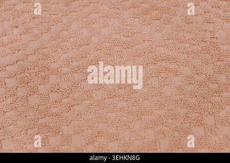 Close up texture of soft pink towel material with geometric woven pattern. Bathroom comfort and textile design concept. Stock Photo