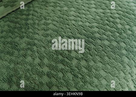Green towel fabric texture with woven geometric pattern in close detail. Soft bathroom textile and household comfort concept. Stock Photo