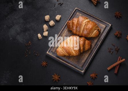 Food, Delicious fresh crispy croissants on a dark concrete background. Tasty breakfast Stock Photo