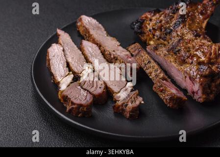 Food, Juicy beef tomahawk steak on the bone baked on the grill with salt and spices on a dark concrete background Stock Photo