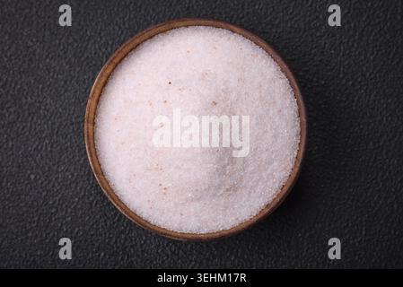 Food, Fine pink Himalayan table salt in a ceramic bowl on a dark concrete background Stock Photo