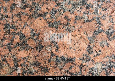 A rock surface is on display with different colors and textures. The close view shows the mineral patterns and details found in nature. Light reflects Stock Photo