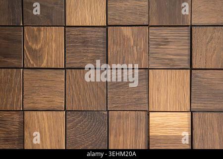 Small wooden tiles are laid out in a grid pattern on a flat surface. The tiles show various shades of brown and different textures. This setup is seen Stock Photo