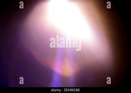 Abstract light flare features soft glowing effects and colorful lens distortion on a dark background, providing a striking visual element for creative Stock Photo