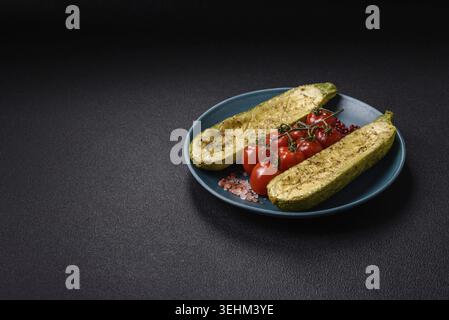 Food, Delicious zucchini cut into two halves baked with salt, spices and herbs on a dark concrete background Stock Photo