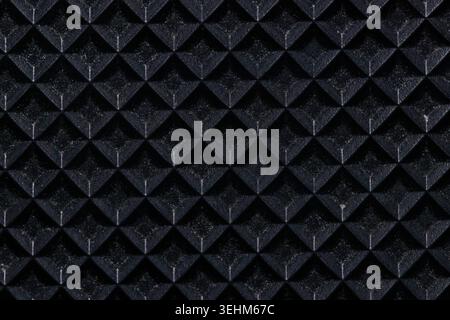 Macro shot of a black rubber running belt texture from a treadmill. Top view of non-slip embossed diamond pattern surface for sports equipment and fit Stock Photo