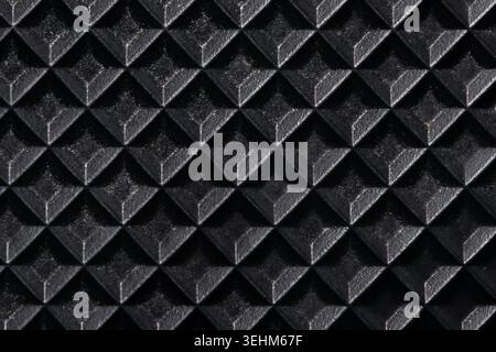Macro shot of a black rubber running belt texture from a treadmill. Top view of non-slip embossed diamond pattern surface for sports equipment and fit Stock Photo